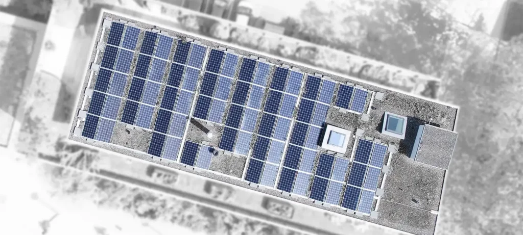 PV-Anlage berechnen – Luftaufnahme von dem Dach eines Geschäftshauses, auf dem Solarmodule installiert sind